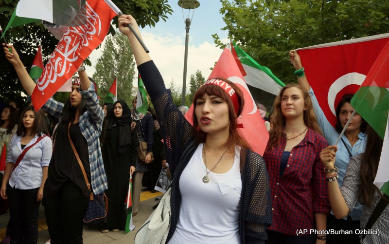 Protesters, many female, with fists raised or holding Palestinian flags.