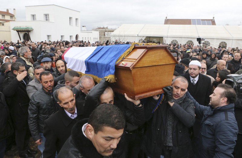 People carry the coffin of slain police officer Ahmed Merabet after a funeral service at the Bobigny Mosque, east of Paris, France, Tuesday, Jan. 13, 2015.  While both the Kouachi Brothers' killings and Lubitz's deliberate crash of the Germanwings flight were brutal tragedies, media treatment of each has been noticeably different. (AP Photo/Jacques Brinon)