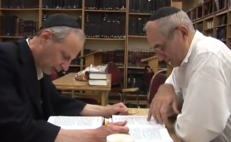 Yakov Rabkin and another man study documents in a library. Rabkin, a professor and Jewish scholar working in Montreal, believes that there is an essential conflict between Jewish ethics and the Zionist behavior of Israel, in particular its treatment  of Palestinians. 