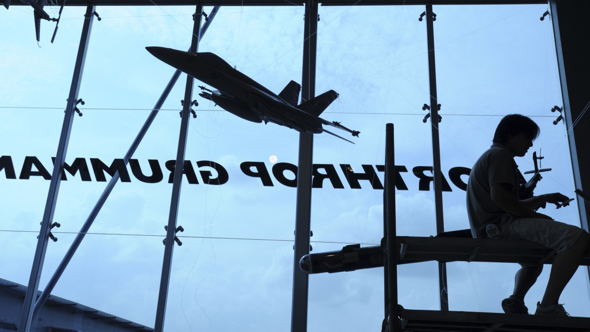 In this Feb. 15, 2008 file photo, a contractor is silhouetted while assembling model planes in the exhibition booth of Northrop Grumman at the site of the Singapore Airshow. (AP Photo/Wong Maye-E, File)