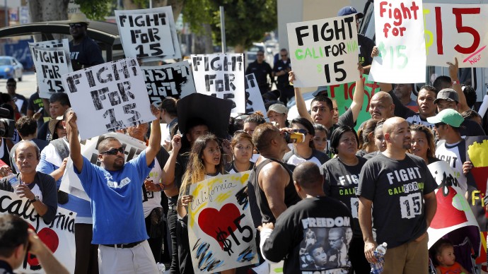 FILE - In this Aug. 29, 2013, file photo, protestors demonstrate outside a fast-food restaurant in Los Angeles. Thousands of fast-food workers and their supporters have been staging protests across the country to call attention to the struggles of living on or close to the federal minimum wage. The push raises the question of whether the economics of the fast-food industry allow room for a boost in pay for its workers. (AP Photo/Nick Ut, File)