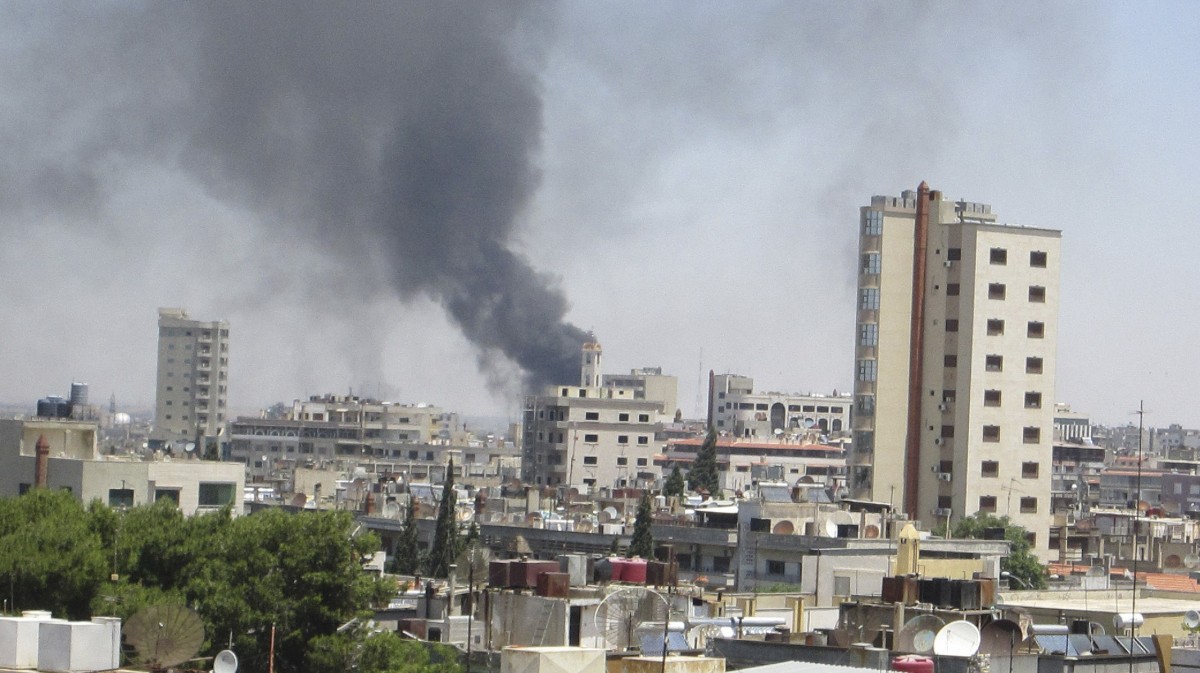 In this image made available on Tuesday June 12, 2012 smoke rises from a residential area of Talbisah in Homs city Syria Saturday June 9, 2012. (AP Photo/David Manyua/United Nations )