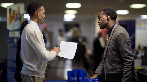 FILE - In this Thursday, Nov. 14, 2013, file photo, retired U.S. Air Force Master Sgt. Thomas Gipson, of Atlanta, right, has his resume looked over by Ralph Brown, a management and program analyst with the Centers for Disease Control and Prevention, during a job fair for veterans at the VFW Post 2681,Marietta, Ga. The Labor Department reports on the number of people who applied for U.S. unemployment benefits last week on Thursday, Dec. 12, 2013. (AP Photo/David Goldman, File)
