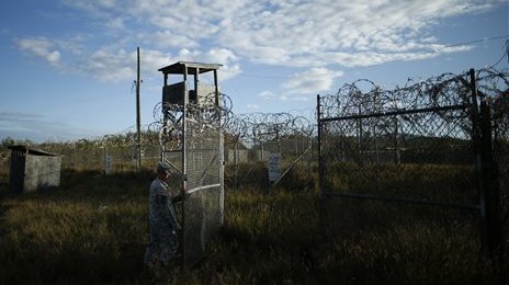 In this photo reviewed by the U.S. military, a soldier closes the gate at the now abandoned Camp X-Ray, which was used as the first detention facility for al-Qaida and Taliban militants who were captured after the Sept. 11 attacks at Guantanamo Bay Naval Base, Cuba, Thursday, Nov. 21, 2013. Detainees were housed in open air pens until the completion of Camp Delta in April 2002. Many detainees at Guantanamo Bay may be closer to heading home under a bipartisan deal reached in Congress that gives President Barack Obama a rare victory in his fight to close the prison for terror suspects. (AP Photo/Charles Dharapak)