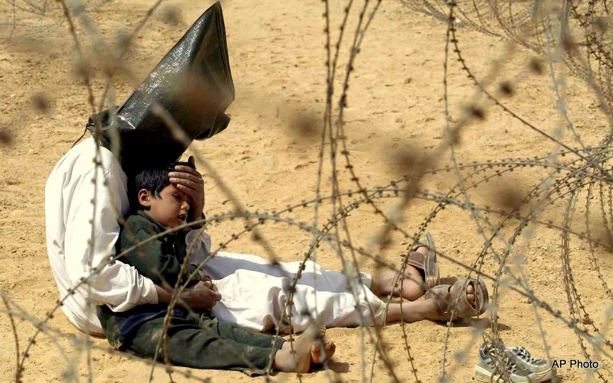 In this March 31, 2003 file photo, an Iraqi prisoner of war comforts his 4-year-old son at a regrouping center for POWs captured by the U.S. Army 101st Airborne Division near An Najaf, Iraq. The man was seized in An Najaf with his son by the U.S. military.