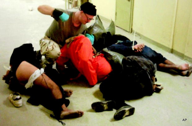 Cpl. Charles A. Graner Jr. appearing to punch one of several handcuffed detainees lying on the floor in late 2003 at the Abu Ghraib prison in Baghdad, Iraq. (AP Photo)