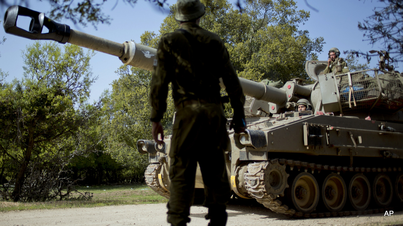 An Israeli soldier looks at a mobile artillery unit heading towards a position near the border with Syria in the Israeli controlled Golan Heights, Monday, April 27, 2015. (AP/Ariel Schalit)