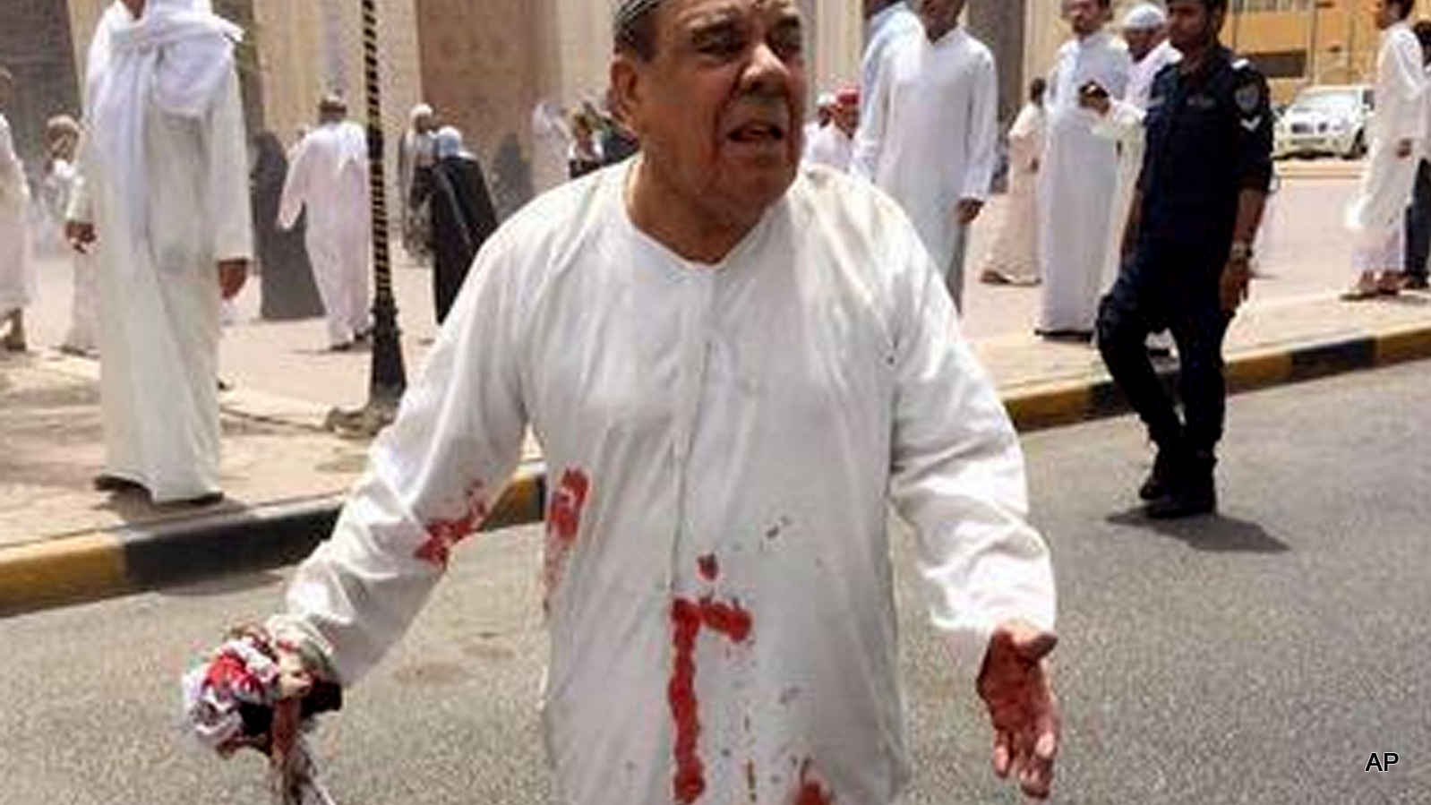 a man in a blood-soaked dishdasha following of a deadly blast at a Shiite mosque in Kuwait City