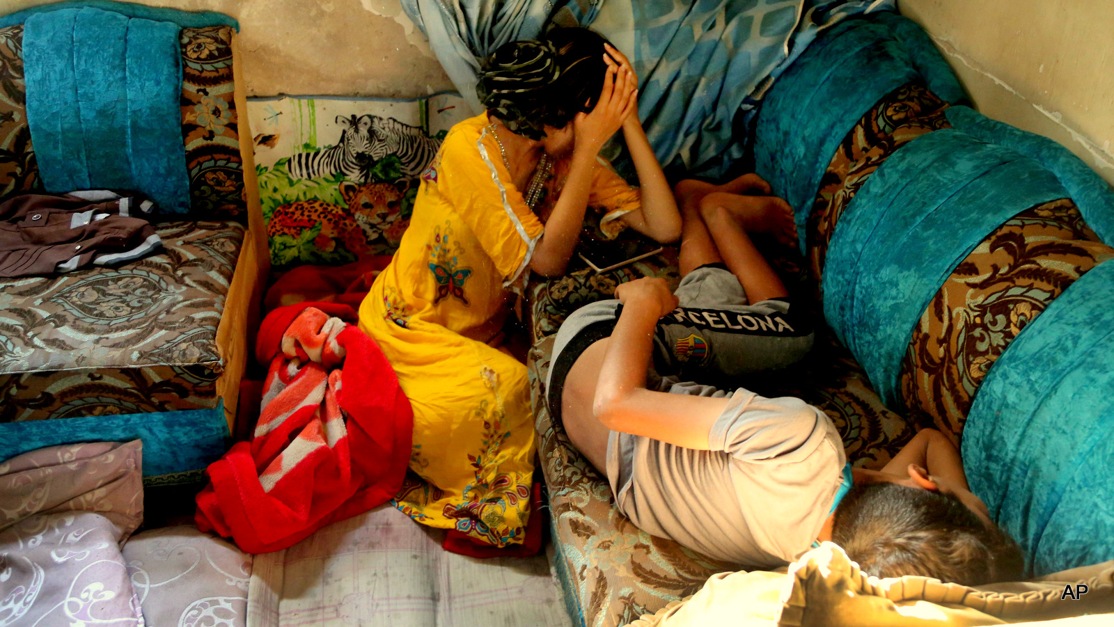 Afrah Hussein, 13, grieves at her apartment near the site of a bomb attack in the aftermath of a car bomb explosion in the impoverished neighborhood of al-Bayaa in southwestern Baghdad, Iraq, Thursday, July 23, 2015. A pair of car bombs exploded Wednesday at crowded popular markets in predominantly Shiite neighborhoods of the Iraqi capital, Baghdad, killing and wounding civilians, officials said.