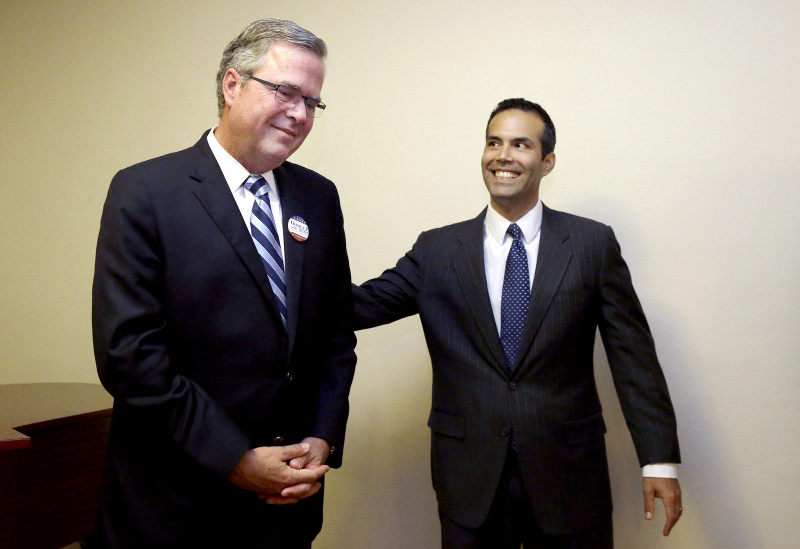 File - In this Oct. 4, 2014 file photo, George P. Bush, right, reaches to his father, former Florida Gov. Jeb Bush after the senior Bush became emotional when expressing his pride for his son while speaking to supporters at Hardin-Simmons University, in Abilene, Texas. George P. Bush has been helping members of his famous family get elected since age 3 but has never played a larger role as a political surrogate than this cycle, as he tries to help his dad follow his grandfather, George H.W. Bush, and his uncle, George W. Bush, to the White House. (AP Photo/LM Otero, File)
