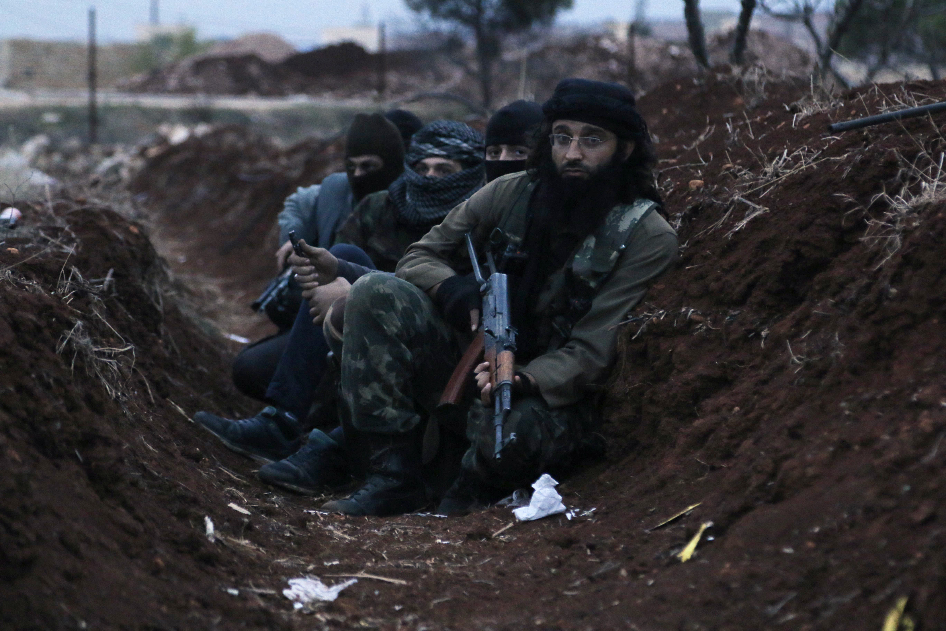 Members of al Qaeda's Nusra Front carry their weapons as they sit in a trench near al-Zahra village, north of Aleppo city, November 25, 2014. (REUTERS/Hosam Katan)