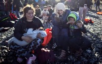 A Yazidi refugee family from Iraq cries while resting on the seashore shortly after arriving on a vessel from the Turkish coast to the northeastern Greek island of Lesbos, Thursday, Nov. 26, 2015. About 5,000 migrants are reaching Europe each day along the so-called Balkan migrant route, stoking tensions among the countries along the migrant corridor including Greece, Macedonia, Serbia, Croatia and Slovenia. (AP Photo/Muhammed Muheisen)