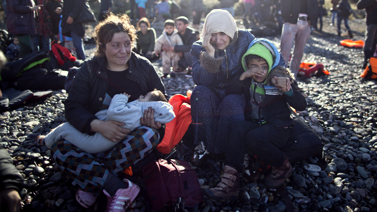 A Yazidi refugee family from Iraq cries while resting on the seashore shortly after arriving on a vessel from the Turkish coast to the northeastern Greek island of Lesbos, Thursday, Nov. 26, 2015. About 5,000 migrants are reaching Europe each day along the so-called Balkan migrant route, stoking tensions among the countries along the migrant corridor including Greece, Macedonia, Serbia, Croatia and Slovenia. (AP Photo/Muhammed Muheisen)