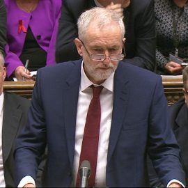 Opposition Labour Party leader, Jeremy Corbyn, centre, stands as he makes a speech to lawmakers inside the House of Commons in London, during a debate on launching airstrikes against ISIS extremists inside Syria, Wednesday, Dec. 2, 2015. Shadow Foreign Secretary Hilary Ben sitting left, and Labour Party Deputy leader Tom Watson, right. The parliamentary vote is expected Wednesday evening. (Parliamentary Recording Unit via AP Video)