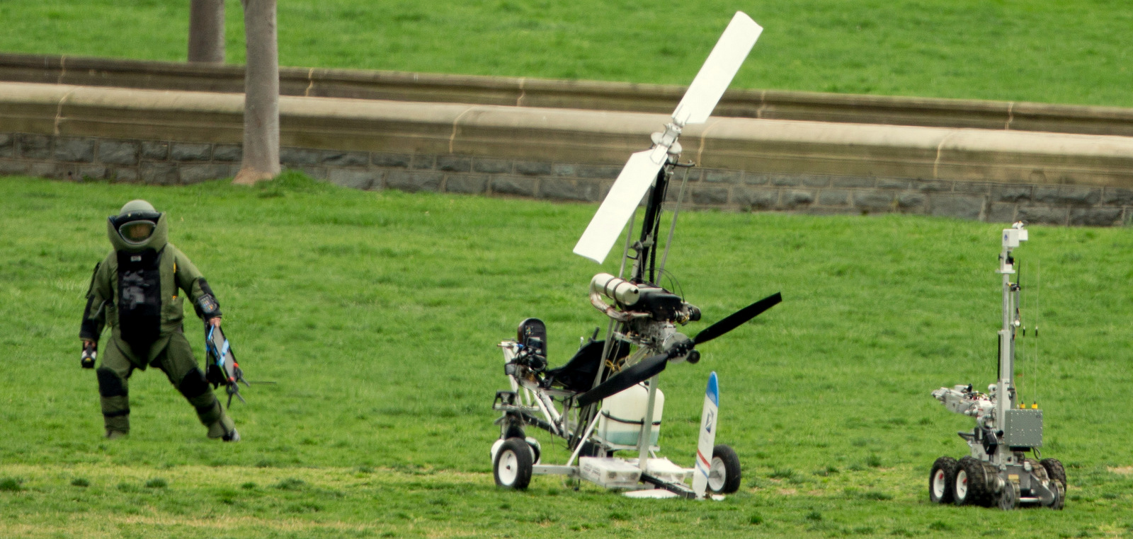 A member of a bomb squad approaches the gyrocopter of Doug Hughes after it landed on the West Lawn of the Capitol in Washington, where Hughes hoped to deliver letters to all 535 members of Congress in order to draw attention to campaign finance corruption. Wednesday, April 15, 2015. (AP Photo/Andrew Harnik)