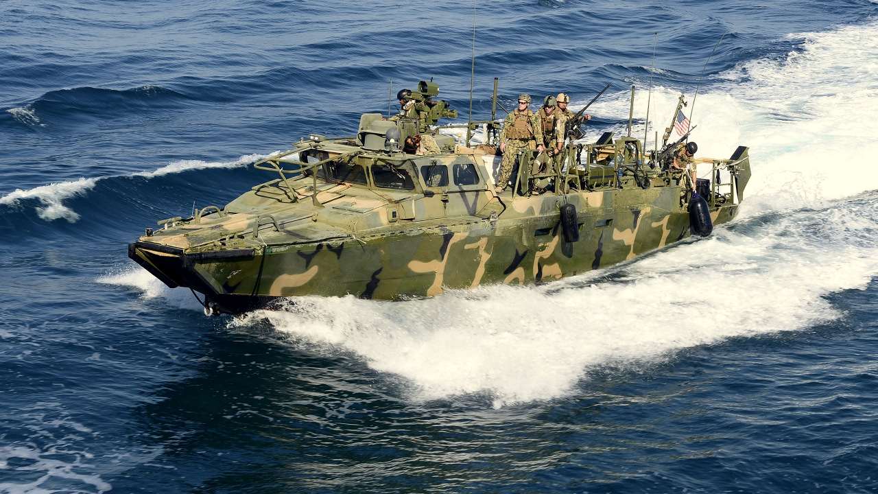 Photo: A Riverine Command Boat from Costal Riverine Squadron (RIVRON) 2 escorts the USS Bunker Hill (CG 52) in the Persian Gulf in 2014.