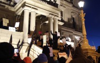 Protesters gather outside the state Capitol before Michigan Gov. Rick Snyder's State of the State address, Tuesday, Jan. 19, 2016, in Lansing, Mich. With the water crisis gripping Flint threatening to overshadow nearly everything else he has accomplished, the Republican governor again pledged a fix Tuesday night during his annual State of the State speech. (AP Photo/Al Goldis)
