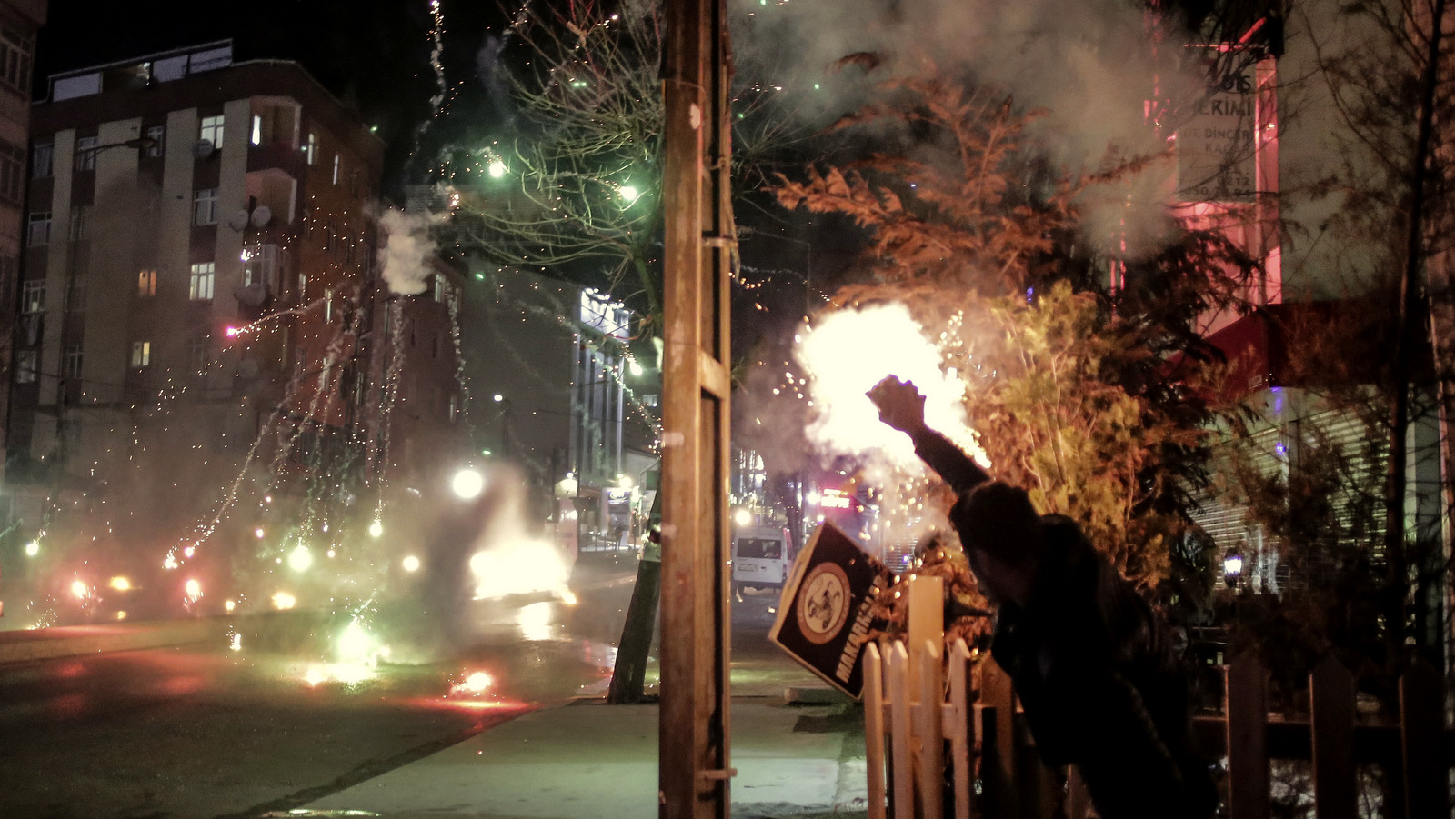 A protester launches firecrackers against a Turkish police water cannon during clashes in Istanbul, Sunday, Feb. 14, 2016, between police forces and people protesting against security operations against Kurdish rebels in southeastern Turkey. Turkey imposed curfews in mainly Kurdish towns and districts in December while its security forces battled militants linked to the Kurdistan Workers' Party, or PKK, who set up barricades, dug trenches and primed explosives in the areas they have declared to be under Kurdish self-rule. (AP Photo/Cagdas Erdogan)