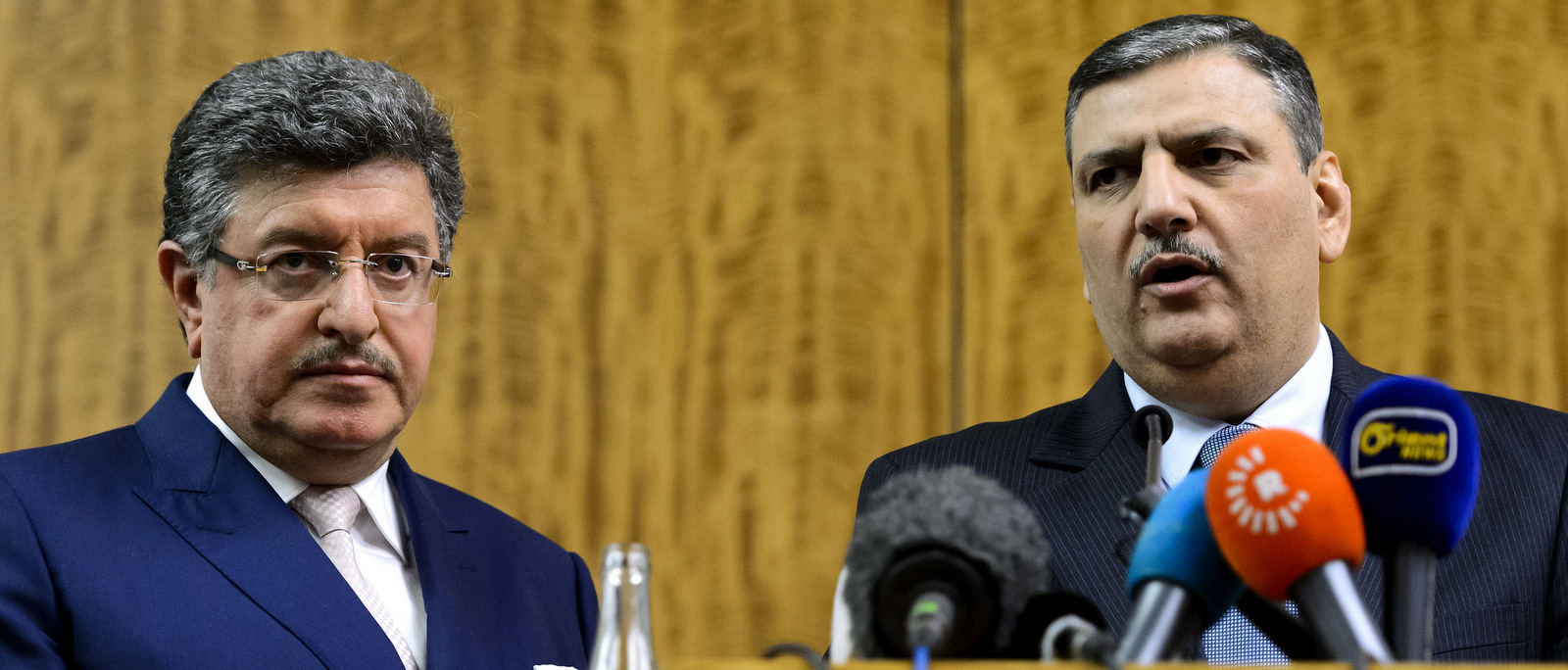 Syrian opposition chief Riad Hijab, right, standing next to High Negotiations Committee (HNC) spokesman Salem al-Meslet, left, as they attend a press conference after Syrian peace talks, at the President Wilson hotel in Geneva, Switzerland, Wednesday, Feb. 3, 2016. (Martial Trezzini/Keystone via AP)