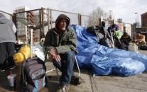 In this Monday, March 7, 2016, photograph, Salvatore Garofalo sits in a lawn chair in a makeshift homeless camp across from the Denver Rescue Mission in downtown Denver. City officials are planning to evict people on Tuesday from the homeless camps that have popped up around homeless shelters and in public places around the Mile High City. (AP Photo/David Zalubowski)