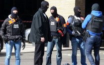 Hooded Belgian police officers patrol outside the Gare du Midi train station in Brussels, Tuesday, March 22, 2016. Explosions, at least one likely caused by a suicide bomber, rocked the Brussels airport and its subway system Tuesday, prompting a lockdown of the Belgian capital and heightened security across Europe. (AP Photo/Michel Spingler)
