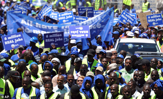 Democratic Alliance members march in Johannesburg, South Africa, Wednesday, Feb. 12, 2014. The skirmish happened Wednesday after followers of the opposition Democratic Alliance marched near the headquarters of the African National Congress, which has dominated politics since the end of white minority rule in 1994. (AP Photo)