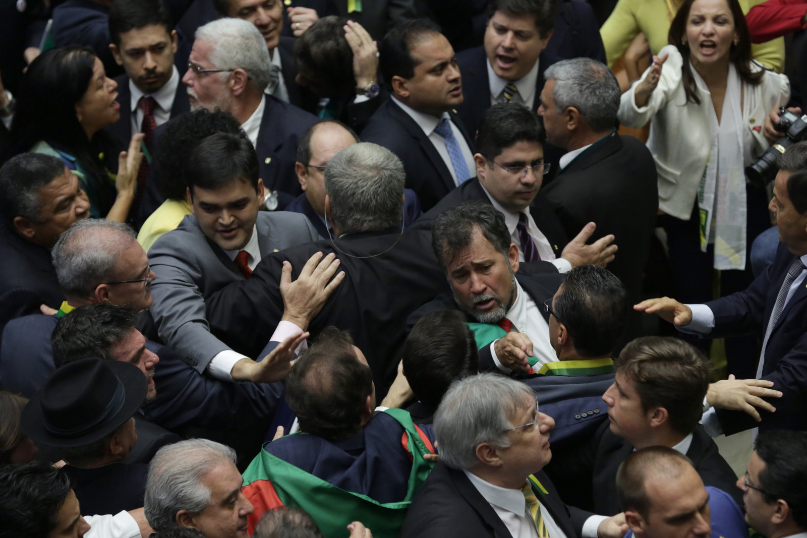 Pro-government lawmakers scuffle with opposition lawmakers during the session on whether or not to impeachment Brazil's President Dilma Rousseff in Brasilia, Brazil, Sunday, April 17, 2016. The vote will determine whether the impeachment proceeds to the Senate. Rousseff is accused of violating Brazil's fiscal laws to shore up public support amid a flagging economy. (AP Photo/Eraldo Peres)