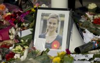 A photograph of Jo Cox, the 41-year-old Member of Parliament fatally shot last week in northern England, stands amongst tributes laid in her memory in Parliament Square, London, after a service of prayer and remembrance to commemorate her, Monday, June 20, 2016. The mother of two was shot on Thursday afternoon in her constituency near Leeds. The man charged with her slaying made a brief appearance in court by video link from prison Monday. (AP Photo/Matt Dunham)