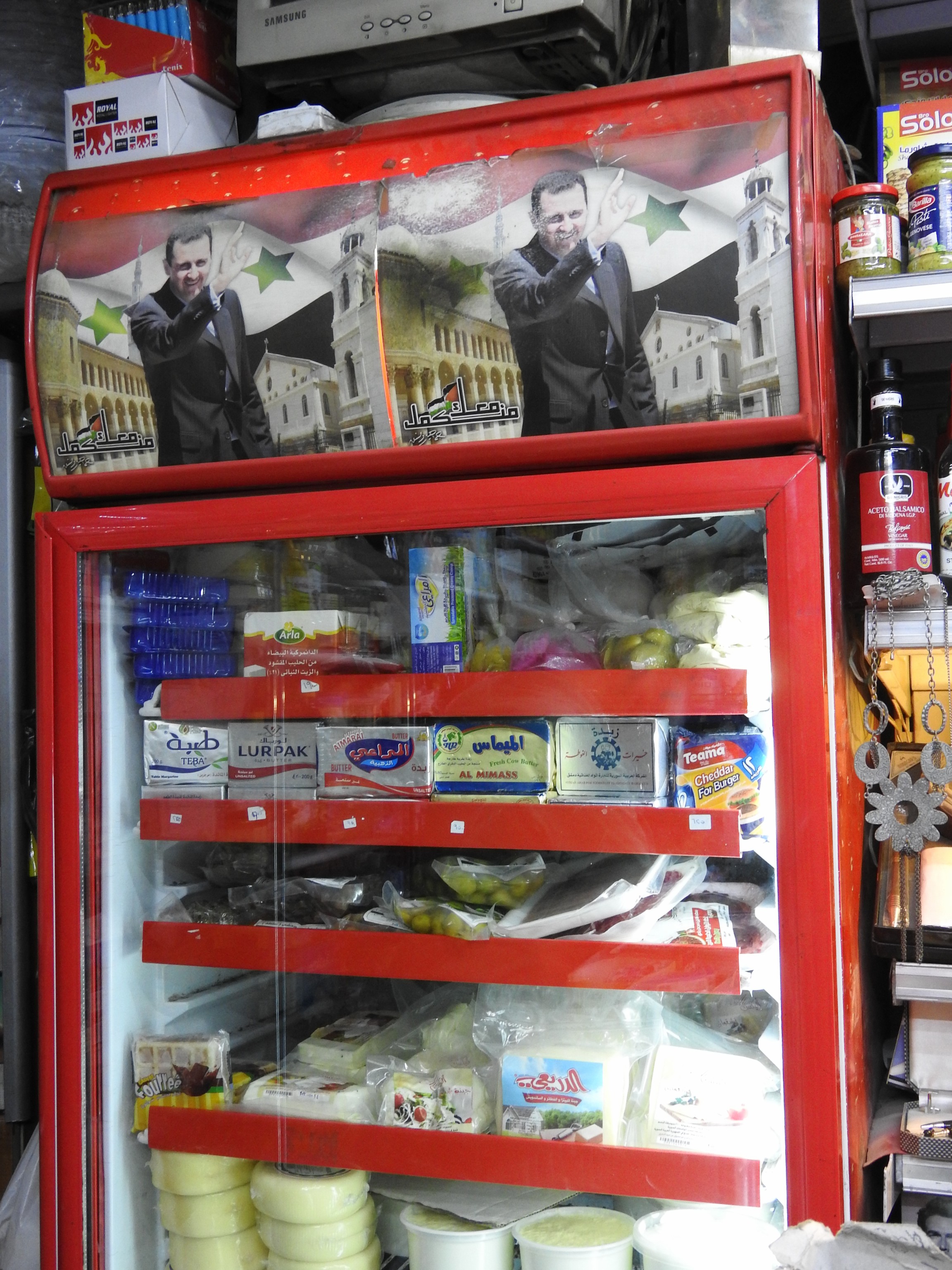 Stopping to buy water in an Old City shop, the owner's only issue with me taking a photograph of his fridge is that he wants to dust off the photos of President Assad a bit first, apologizing that they are old, from well-before the current crisis.