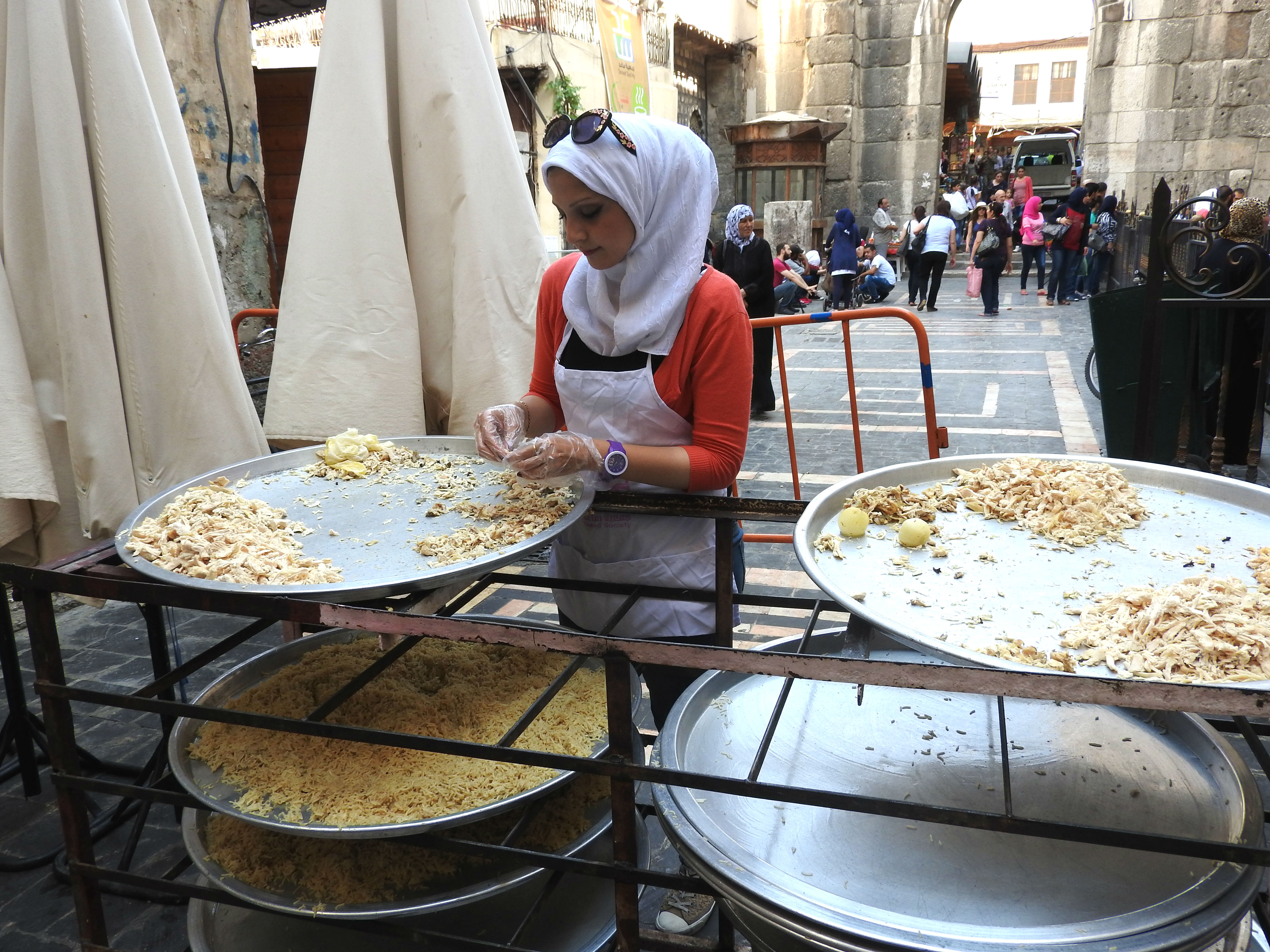  Behind the Umayyad Mosque in Old Damascus, one of tens of volunteers daily helps prepare the Iftar (fast-breaking) meals that the Saaed Association was serving to impoverished Damascus residents, even delivering to those unable to pick up meals themselves. Starting with 3,000 recipients, by the end of Ramadan, the volunteers were providing 10,000 meals daily in Damascus alone, with another combined 7,000 meals prepared in Hama and Homs.