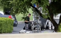 Police setup a remotely operated robot during a stand off with a gunman barricaded inside a van at a Jack in the Box restaurant at Interstate 45 and Dowdy Ferry Road, Saturday, June 13, 2015, in Hutchins, Texas. The same type of device was used to kill the suspected gunmen in the recent attack on police in Dallas, Texas.