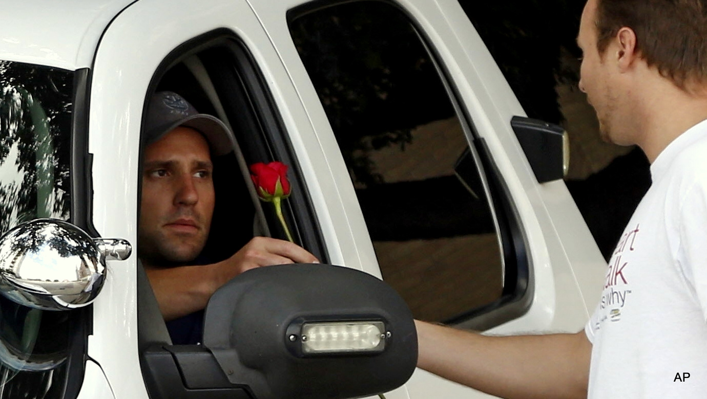 John Fife hands a police officer a rose in Dallas. Texas.