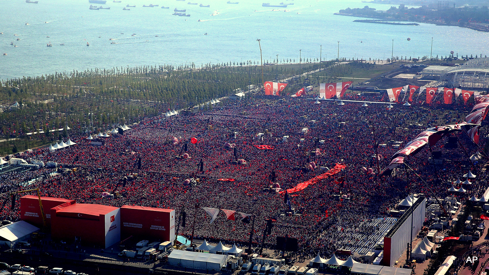 Turkish people wave flags of their country as they take part in a Democracy and Martyrs' Rally in Istanbul, Sunday, Aug. 7, 2016.