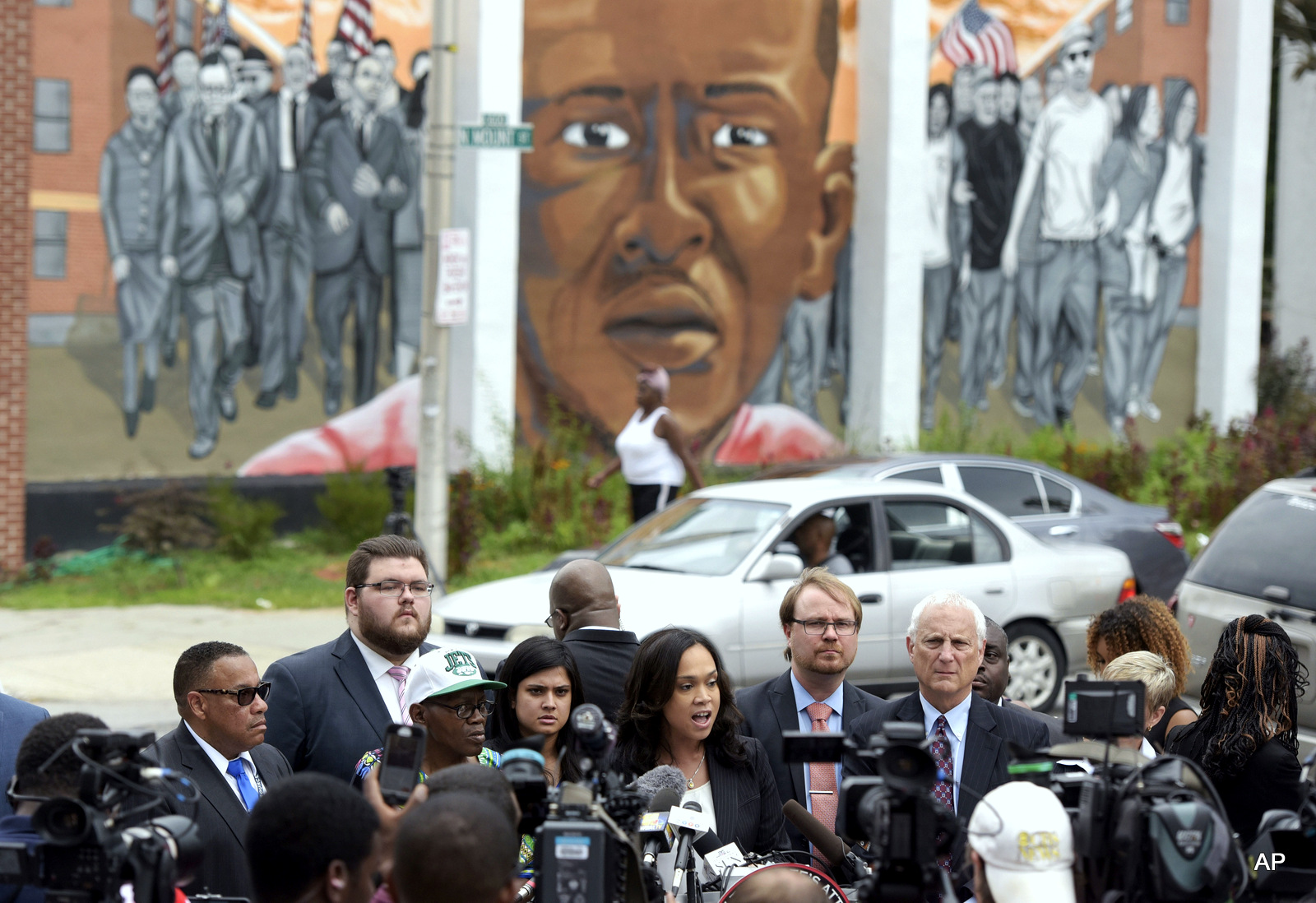 A mural depicting Freddie Gray in the background, Baltimore State's Attorney Marilyn Mosby, center, speaks during a news conference after her office dropped remaining charges against the three Baltimore police officers who were still awaiting trial in Freddie Gray' death in Baltimore.