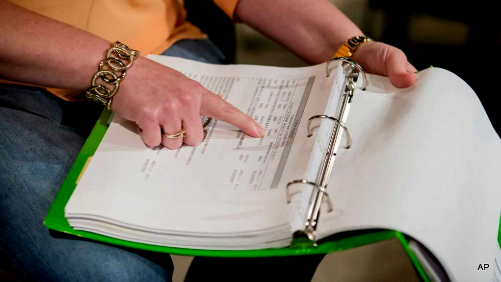 Deb Roschen goes through notebooks of evidence of how authorities accessed information about her through law enforcement databases, during an interview in Rochester, Minn., on July 11, 2016.