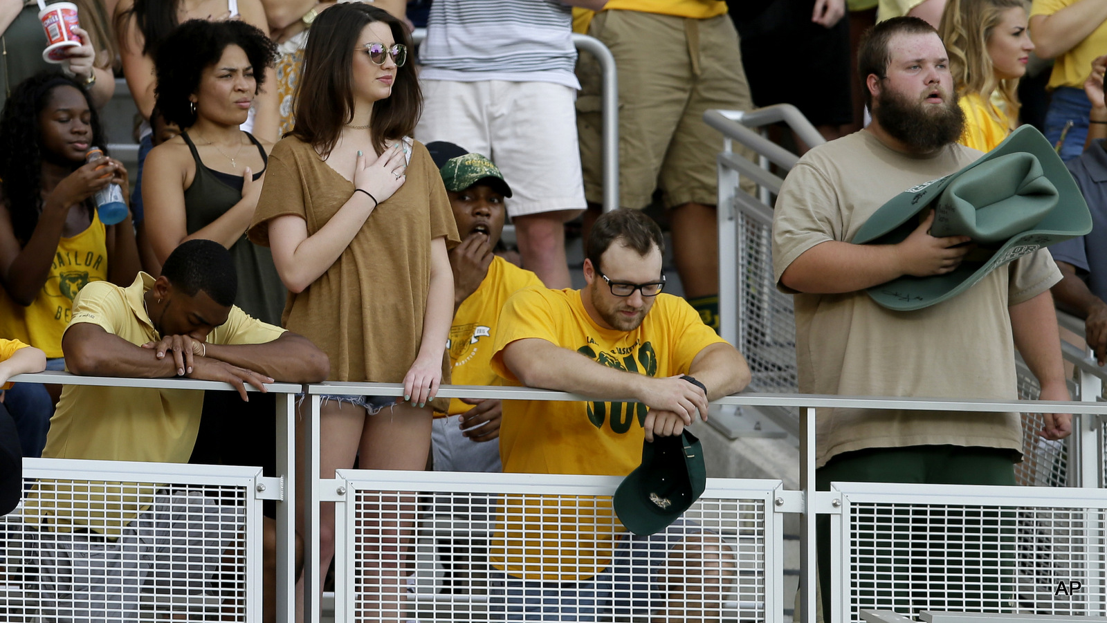 Students in the stands kneel during the national anthem before an NCAA college football game between Oklahoma State and Baylor, Saturday, Sept. 24, 2016, in Waco, Texas.