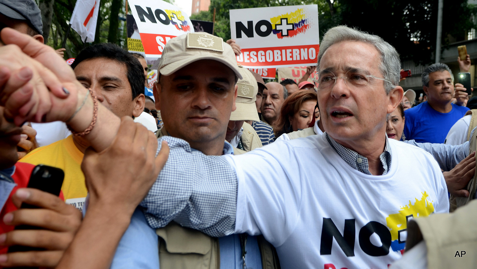 Opposition leader and former President Alvaro Uribe shakes hands with a supporter as he takes part in a protest against President Juan Manuel Santos' government and to denounce the concessions the government has made in peace talks with the Revolutionary Armed Forces of Colombia, or FARC, in Medellin, Colombia. 