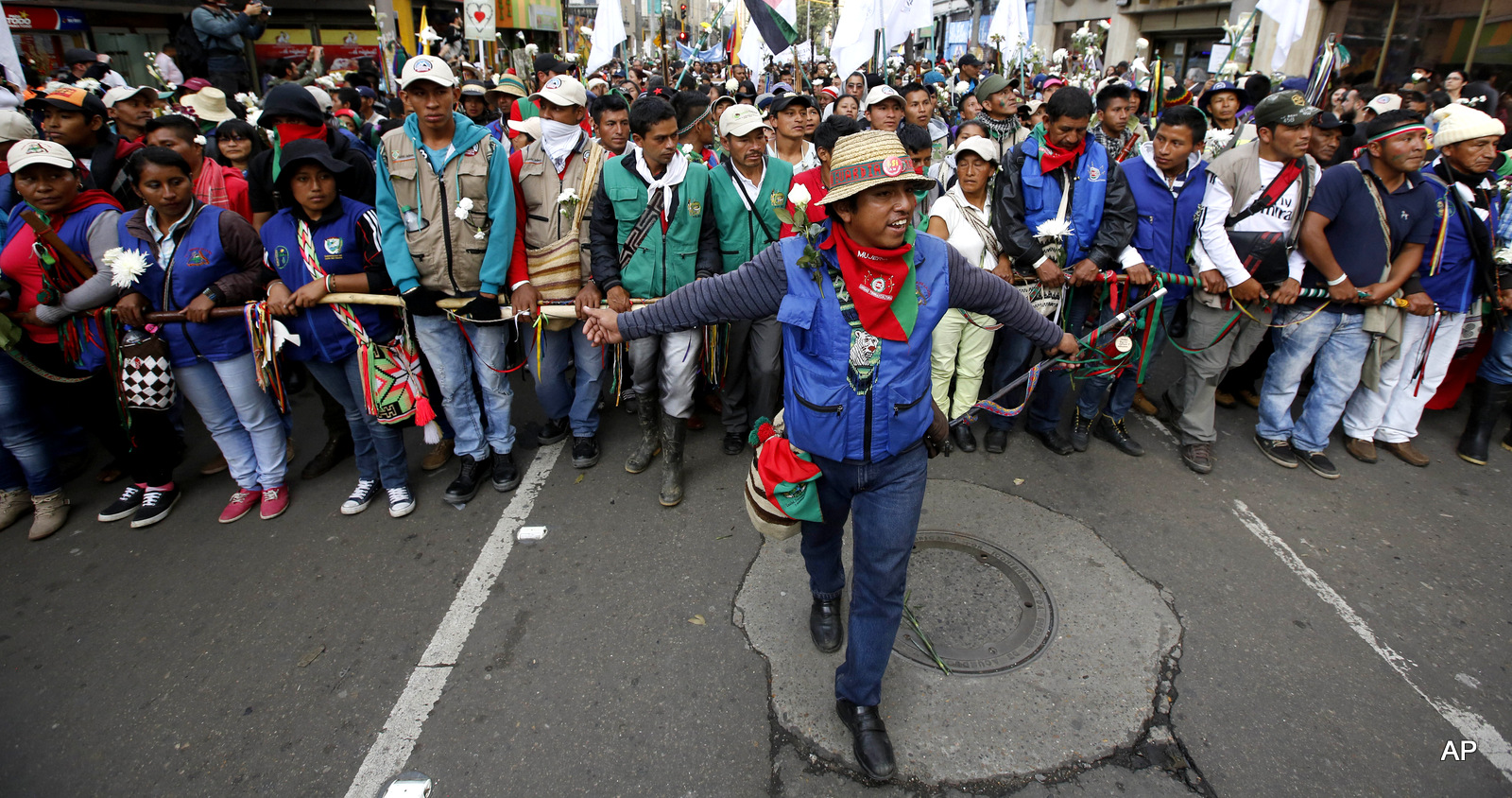 People participate in a peace march in Bogota, Colombia, Wednesday, Oct. 12, 2016. Thousands of rural farmers, indigenous activists and students marched in cities across Colombia to demand a peace deal between the government an leftist rebels not be scuttled. 