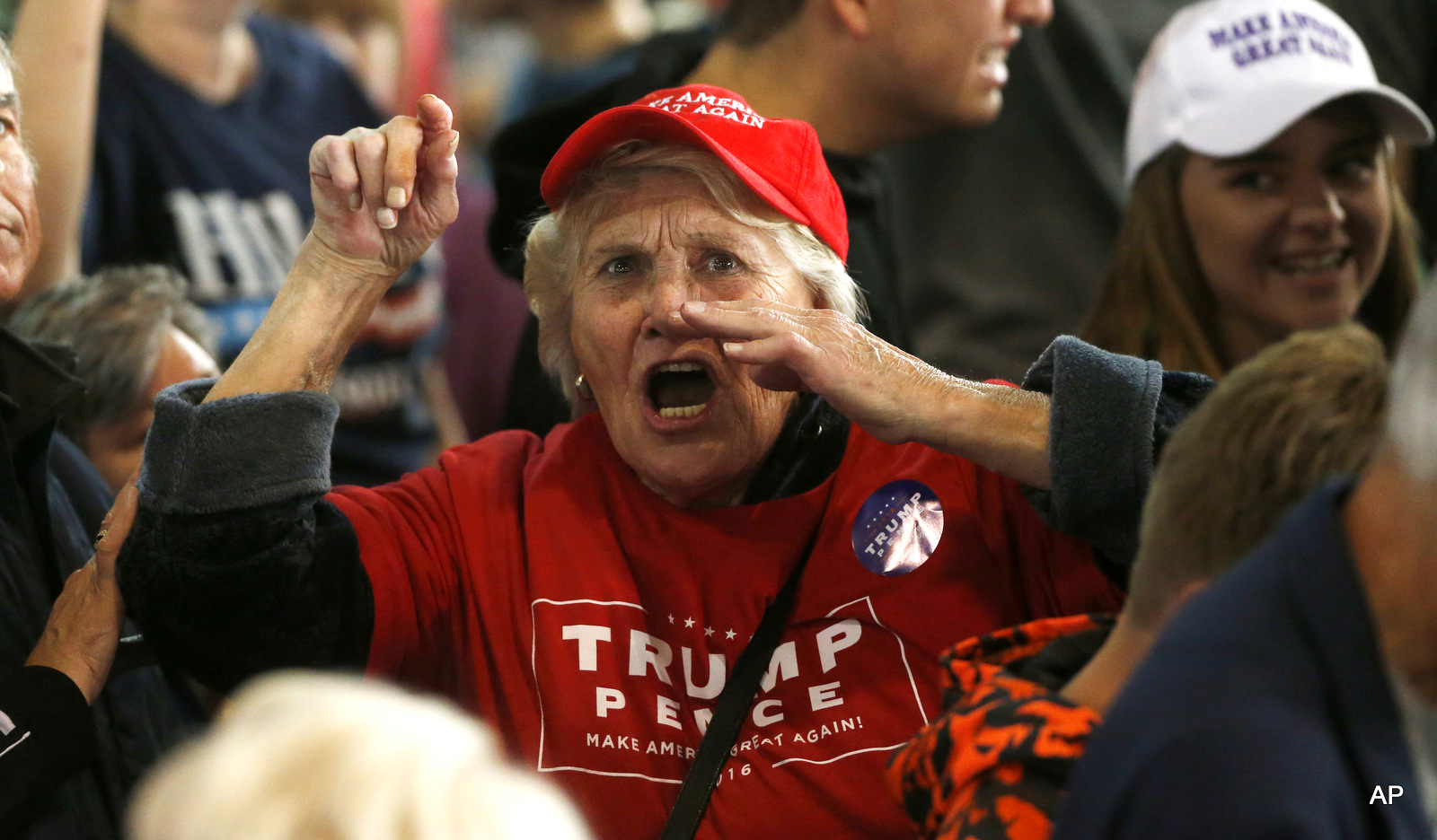 A supporter of Republican presidential candidate Donald Trump berates the media as she leaves a campaign rally for Trump, Tuesday, Oct. 18, 2016, in Colorado Springs, Colo.