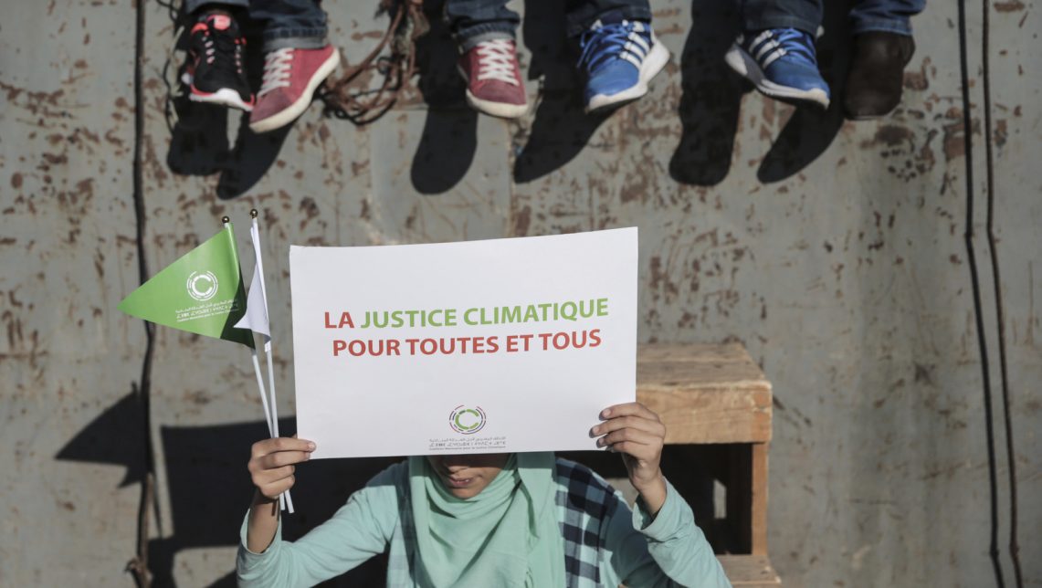 A girl carries a sign saying "Climate justice for all" as she takes part in a protest against climate change coinciding with the Climate Conference, known as COP22, taking place in Marrakech, Morocco, Sunday, Nov. 13, 2016. (AP Photo/Mosa'ab Elshamy)