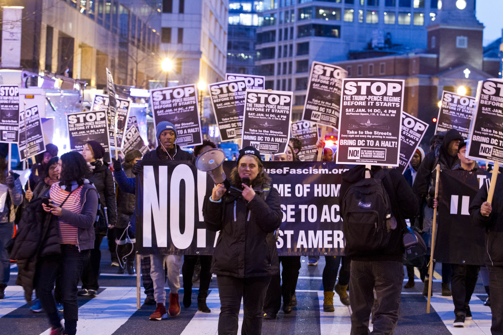 Demonstrators holds banners and signs as they protest during a march in downtown Washington in opposition of President-elect Donald Trump, Sunday, Jan. 15, 2017. (AP/Jose Luis Magana)