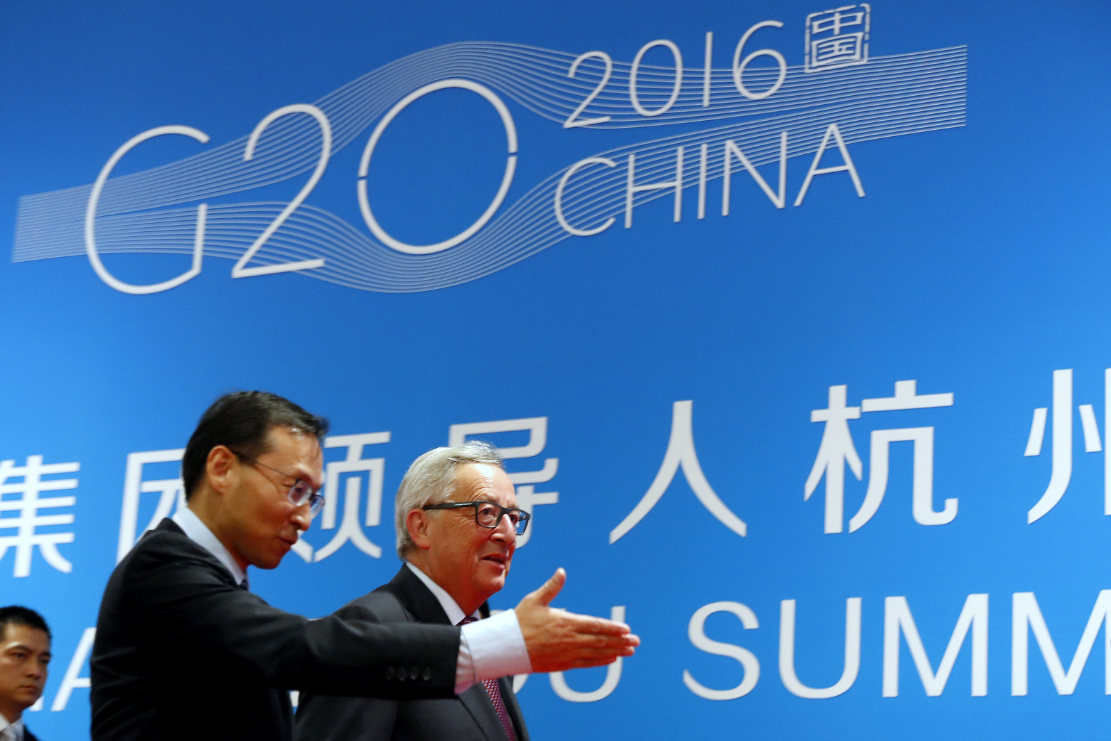 European Commission President Jean-Claude Juncker, right, is shown the way by a Chinese official as he arrives at the G20 Summit in Hangzhou in eastern China's Zhejiang province, Sunday, Sept. 4, 2016. (AP/Ng Han Guan)