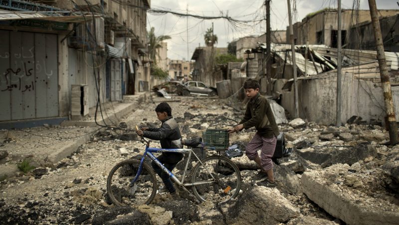 Iraqi boys walk on a destroyed street in a neighborhood recently retaken by Iraqi security forces during fighting against Islamic State militants on the western side of in Mosul, Iraq, Monday, April 3, 2017. (AP/Felipe Dana)