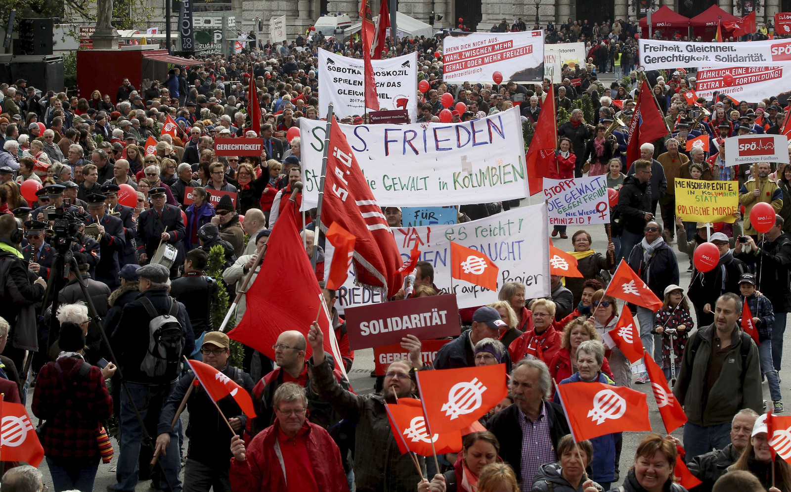 Participants of the traditional May Day celebrations, organized by the Austrian Social Democrats, SPOE, and trade unions walk with flags and banners in Vienna, Austria, Monday, May 1, 2017.
