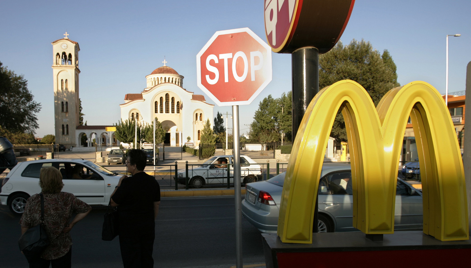 Greek commuters stand near a McDonald's restaurant in Marathon, Greece. (AP/Lefteris Pitarakis)