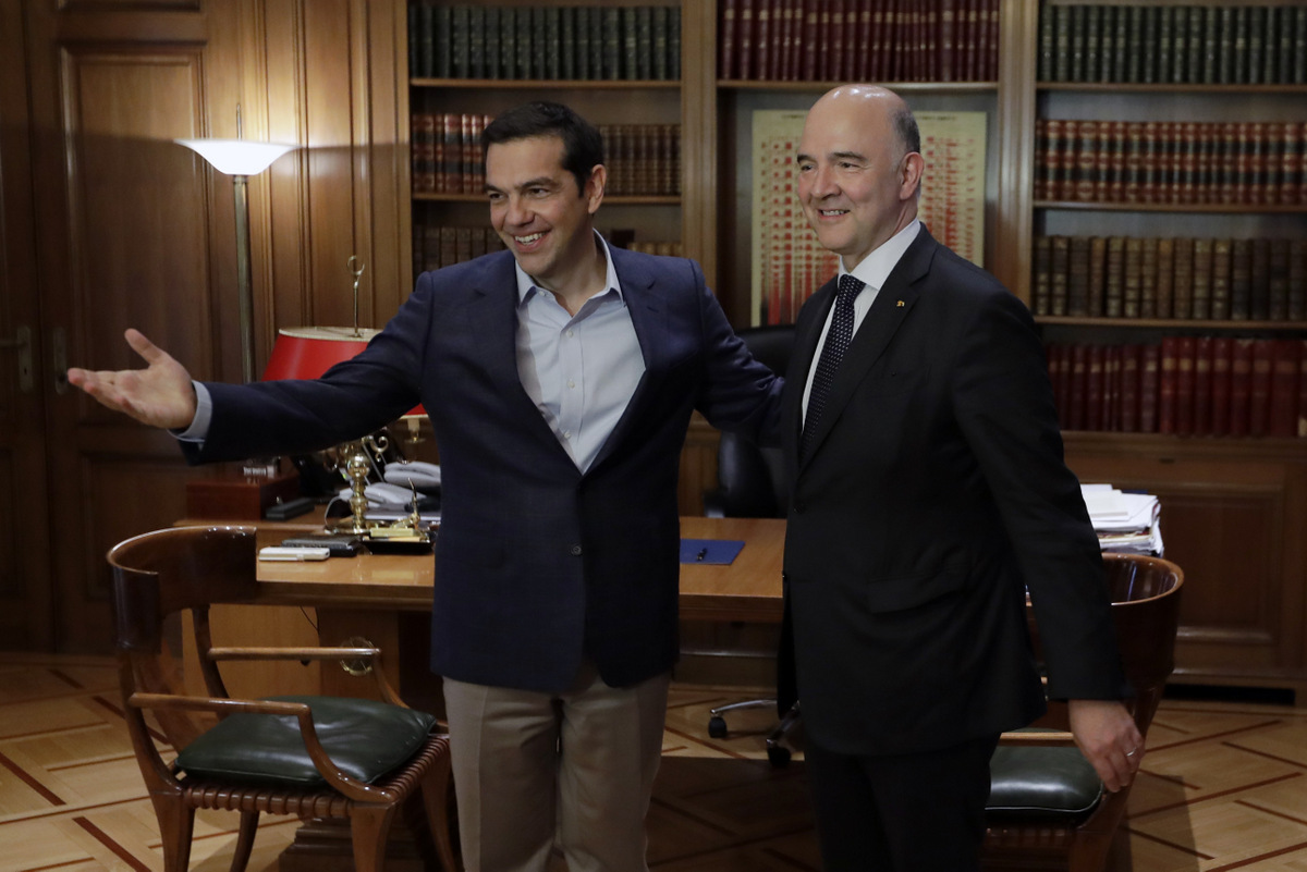 Greek Prime Minister Alexis Tsipras, left, welcomes European Commissioner for Economy Pierre Moscovici at Maximos Mansion in Athens, July 25, 2017. Greece is poised to tap international bond markets for the first time in three years in a move the government claims will signal the country is ready to emerge from its bailout era. (AP/Thanassis Stavrakis)