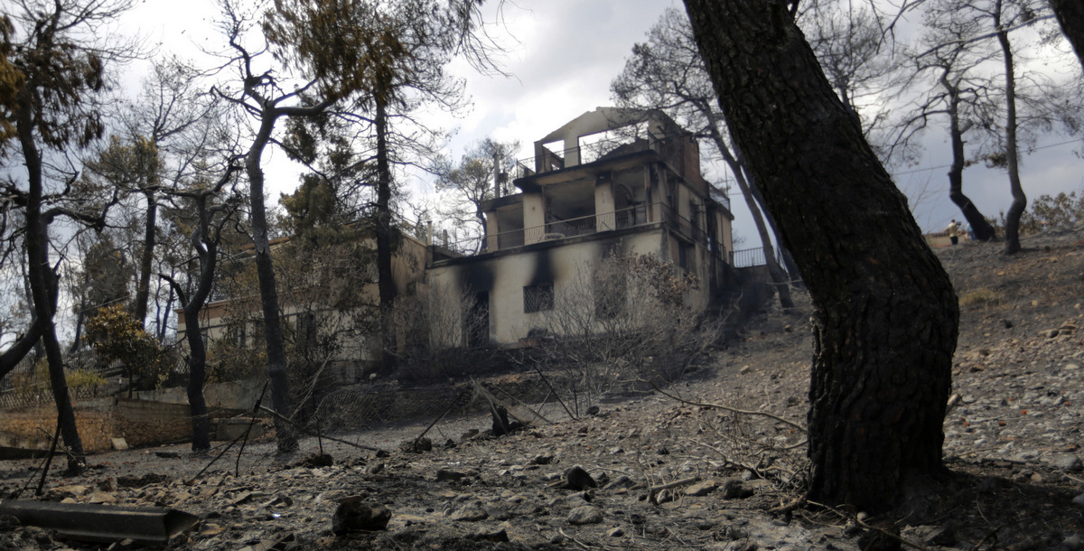 A house damaged by the forest fire stands among pine trees north of Athens, at Kalamos, on, Aug. 16, 2017. (AP/Ioanna Spanou)