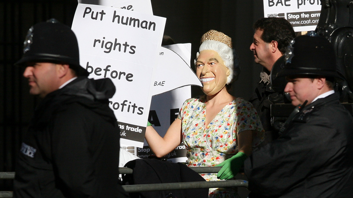A protestor dressed as Queen Elizabeth II is watched by the police at the Mall, London, during the state visit of King Abdullah of Saudi Arabia. A small group of protestors chanted slogans and waved banners highlighting the countries human rights record and the financial scandal over the his countries contract with British company BAE. Tuesday, Oct. 30, 2007. (AP/Simon Dawson)