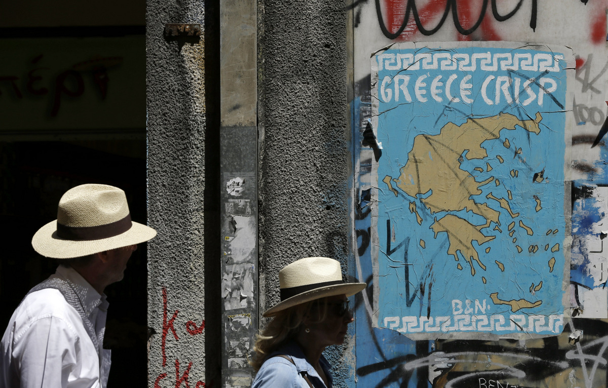Pedestrians pass a poster depicting a map of Greece with the letter E being replaced by Euro symbols in Athens, Tuesday, May 2, 2017. (AP/Thanassis Stavrakis)