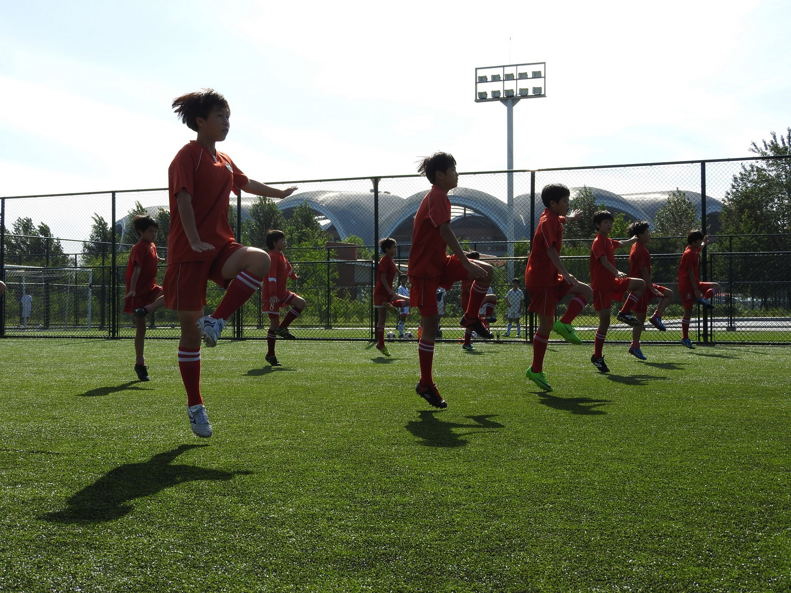 The Pyongyang International Football School opened in 2013. The complex includes a massive stadium and a school teaching all subjects, with football as a focus for the roughly 200 students. Different classes practised their skills outside, doing warm-up drills to energetic music. When years ago I lived in Korea's south, practicing Tae Kwan Do I warmed-up to similar drills.